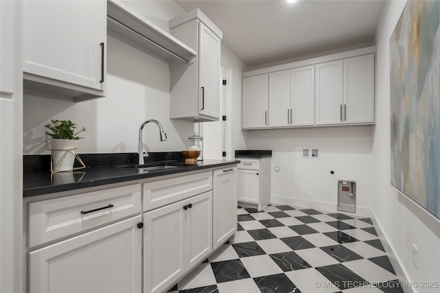 washroom with cabinet space, a sink, hookup for a washing machine, tile patterned floors, and electric dryer hookup