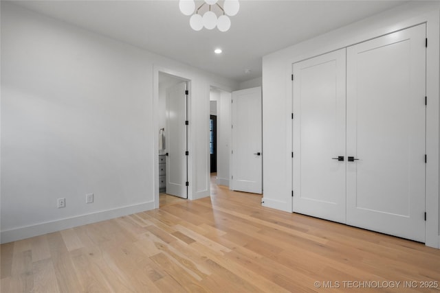 unfurnished bedroom with a closet, baseboards, recessed lighting, connected bathroom, and light wood finished floors