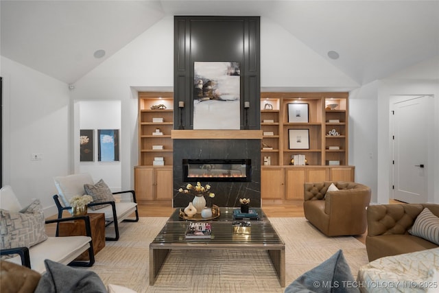 living area featuring high vaulted ceiling, a fireplace, and light wood-type flooring
