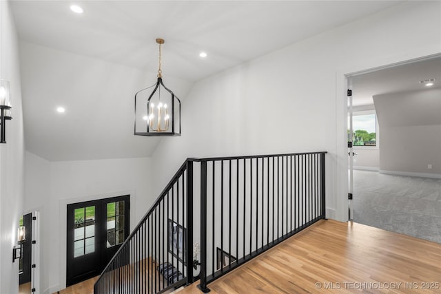 hall with an upstairs landing, carpet floors, high vaulted ceiling, a chandelier, and recessed lighting