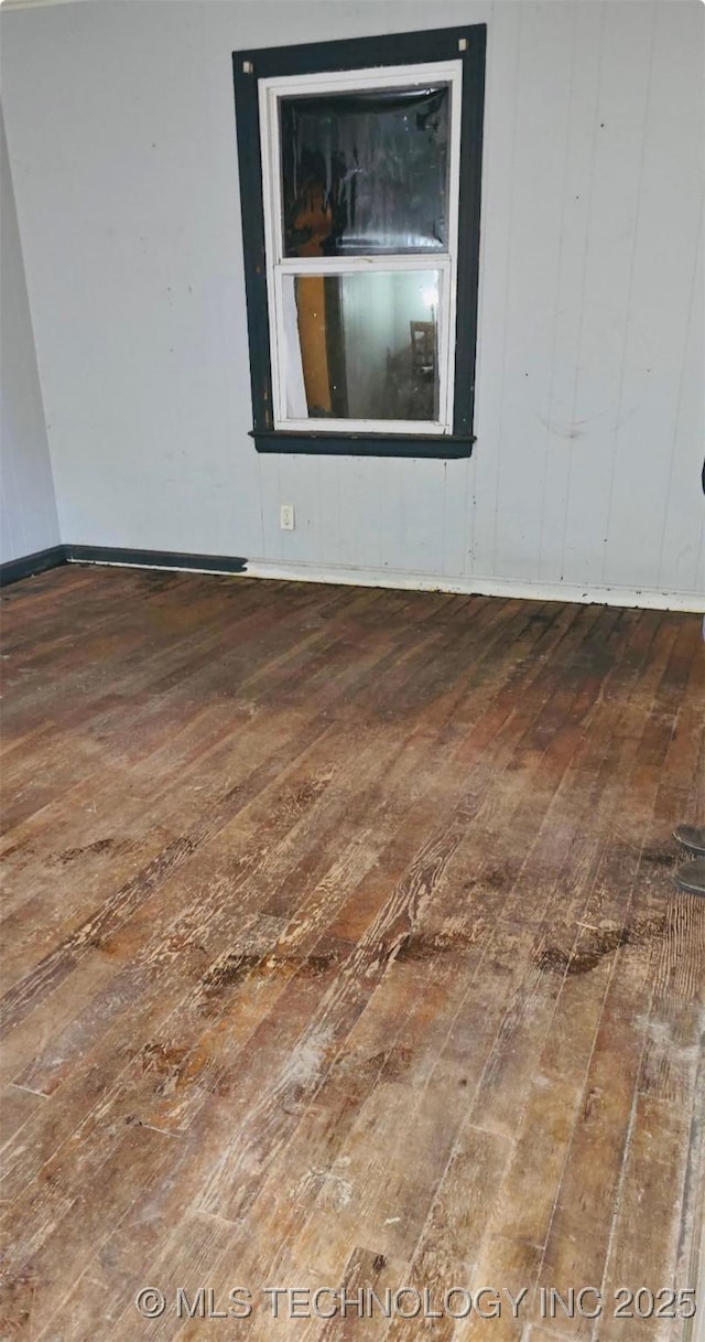 empty room with baseboards and hardwood / wood-style flooring
