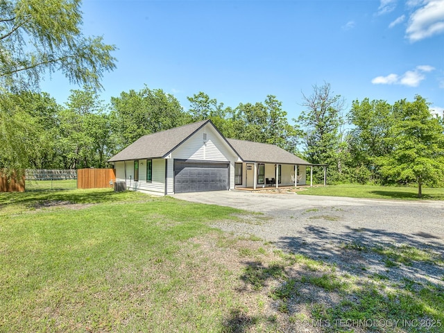 view of front of home featuring fence, driveway, a front lawn, and a garage
