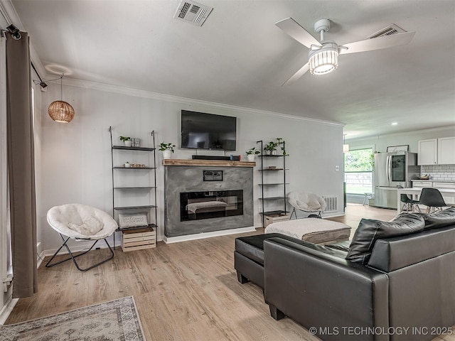 living area featuring a ceiling fan, visible vents, and light wood-type flooring