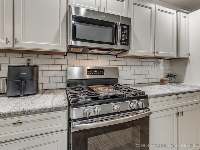 kitchen featuring appliances with stainless steel finishes, decorative backsplash, and white cabinetry