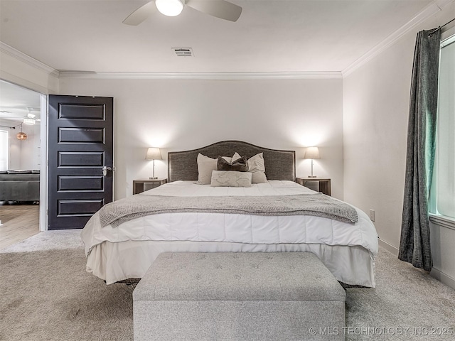 carpeted bedroom featuring crown molding, a ceiling fan, baseboards, and visible vents