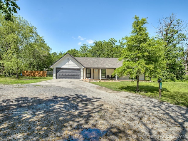 single story home with a garage, a front lawn, fence, covered porch, and driveway