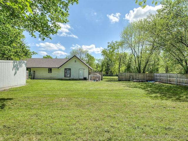 view of yard with a fenced backyard and an outbuilding