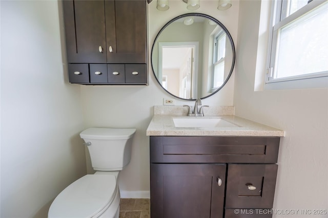 bathroom with toilet, baseboards, and vanity