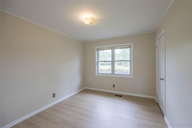 unfurnished room with visible vents, light wood-style floors, and baseboards