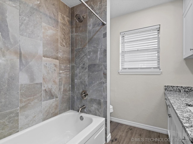 bathroom with shower / bathing tub combination, wood finished floors, vanity, baseboards, and toilet