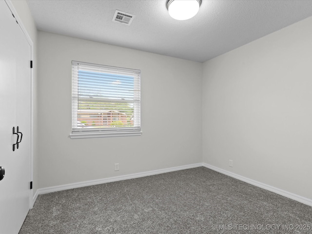 unfurnished room with baseboards, carpet, a textured ceiling, and visible vents
