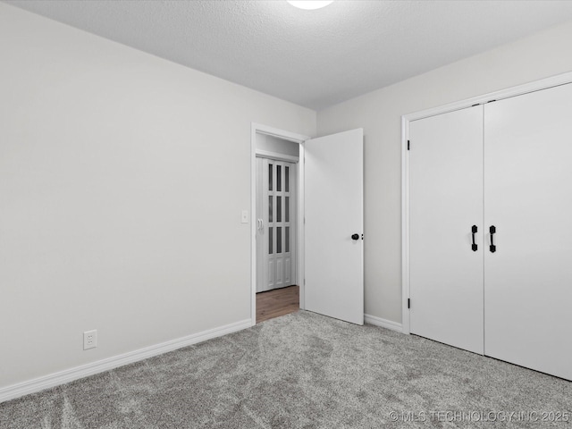 unfurnished bedroom featuring carpet floors, baseboards, and a closet