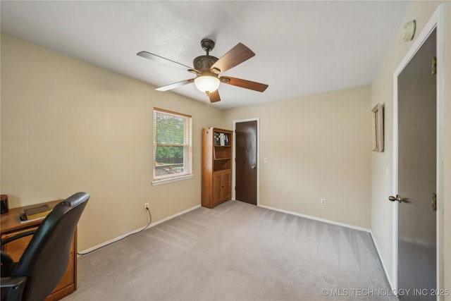 carpeted home office with baseboards and a ceiling fan