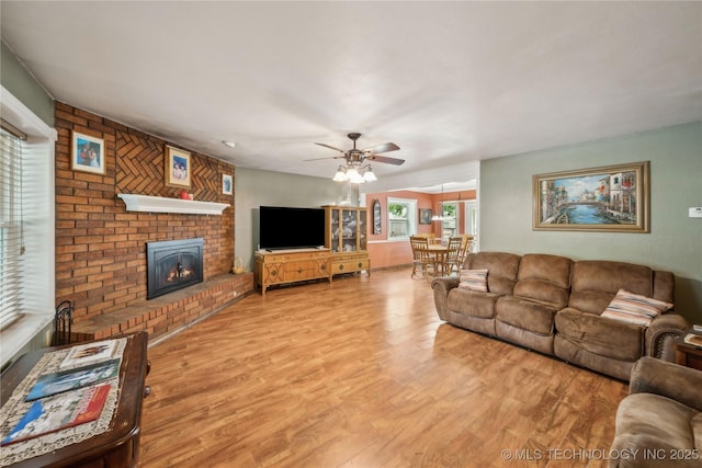 living room with ceiling fan, wood finished floors, and a fireplace