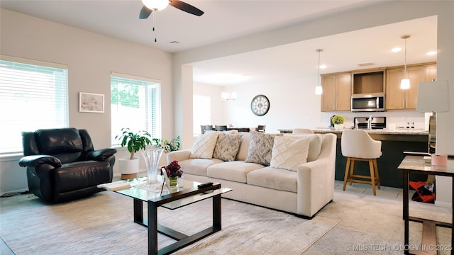 living room with ceiling fan with notable chandelier