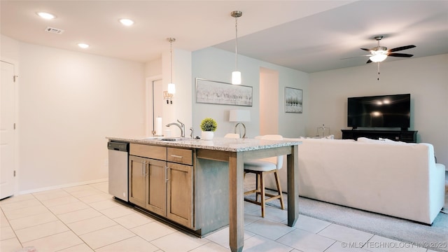 kitchen featuring visible vents, dishwasher, a sink, light tile patterned floors, and open floor plan