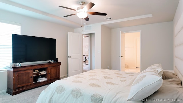 carpeted bedroom with visible vents, connected bathroom, baseboards, and ceiling fan