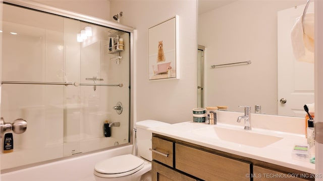 full bath with vanity, shower / bath combination with glass door, and toilet