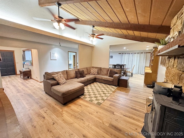 living area with a ceiling fan, lofted ceiling with beams, and light wood-type flooring