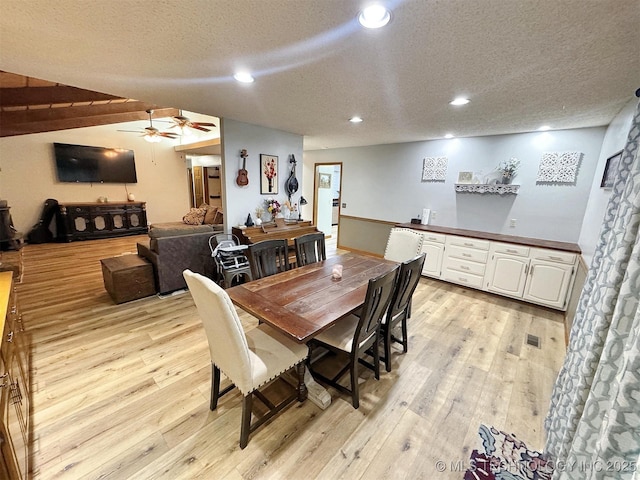 dining area with recessed lighting, a textured ceiling, and light wood-type flooring