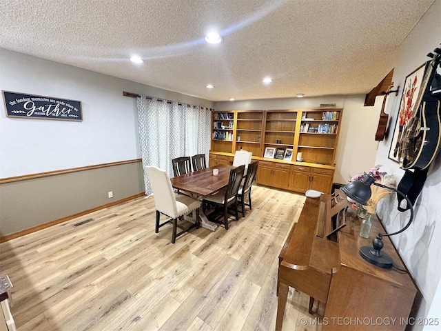 dining area featuring visible vents, baseboards, recessed lighting, a textured ceiling, and light wood-style flooring