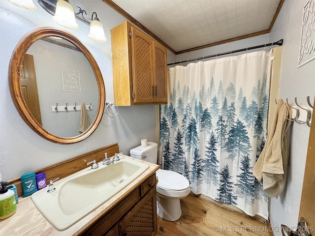 full bathroom with crown molding, vanity, toilet, a textured ceiling, and wood finished floors