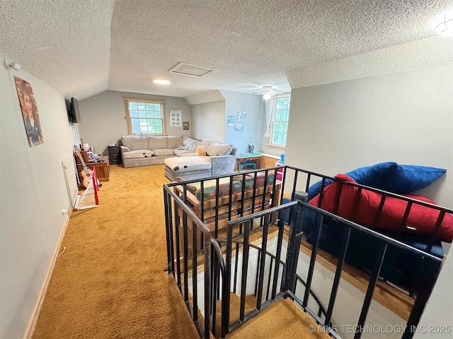 staircase with baseboards, carpet, vaulted ceiling, and a textured ceiling
