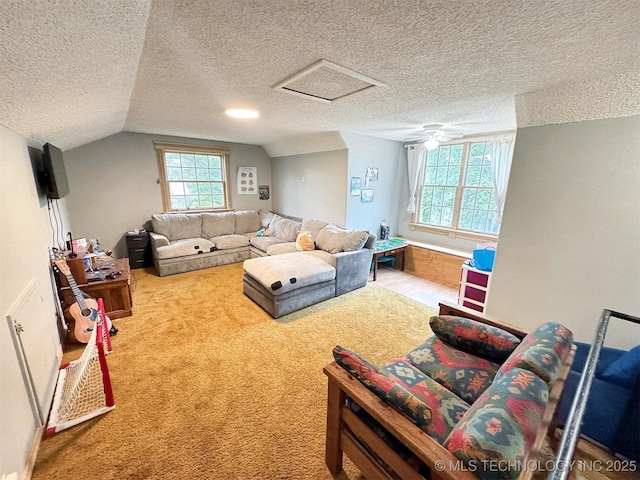 carpeted living room with vaulted ceiling, attic access, and a textured ceiling