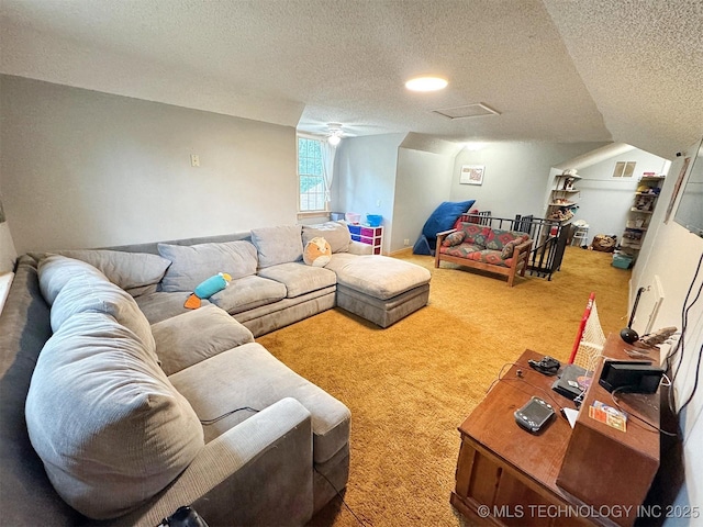 living area featuring a ceiling fan, carpet flooring, a textured ceiling, and visible vents
