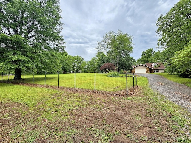 view of yard with fence and driveway