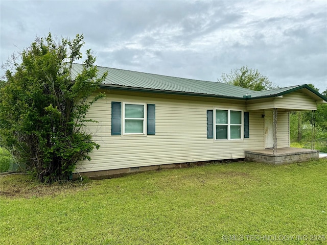 view of side of home with a porch, a lawn, crawl space, and metal roof