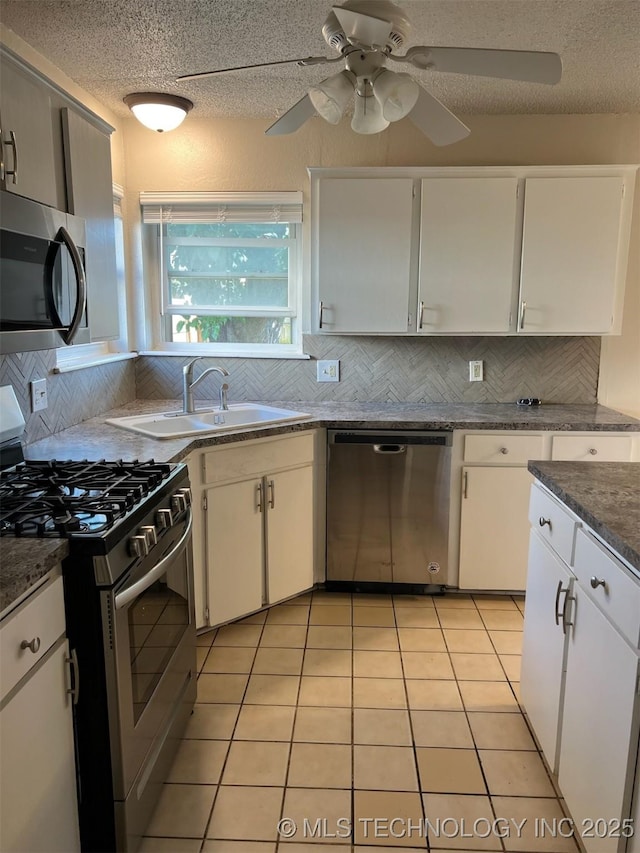 1209 S 29th St, Broken Arrow, OK 74014 - kitchen featuring a sink, appliances with stainless steel finishes, decorative backsplash, and a ceiling fan