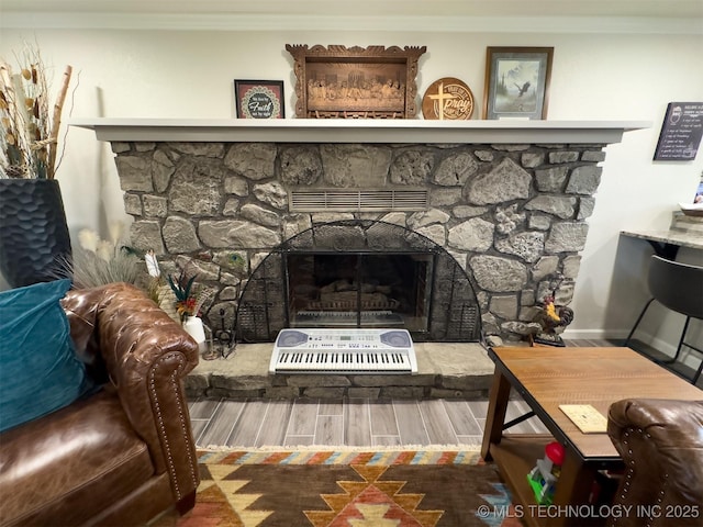 details featuring ornamental molding, wood finished floors, and a fireplace