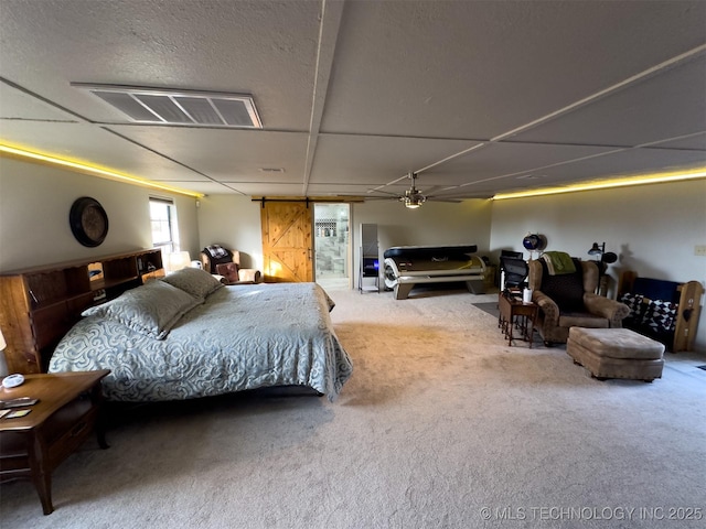 bedroom featuring visible vents, a barn door, and carpet