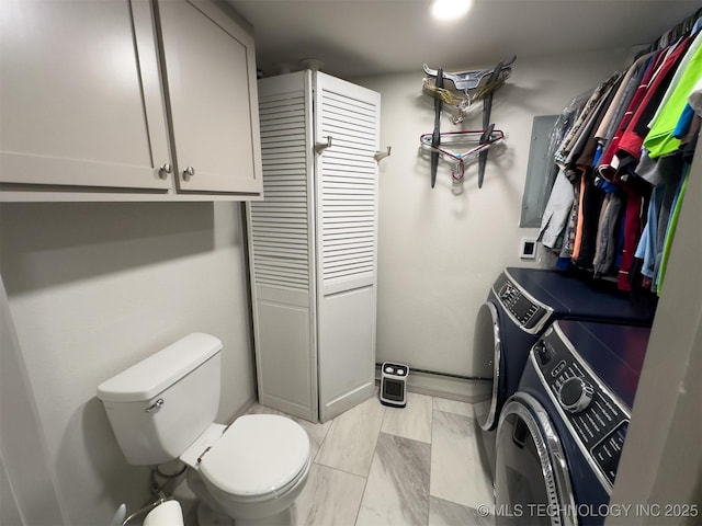 bathroom featuring independent washer and dryer and toilet