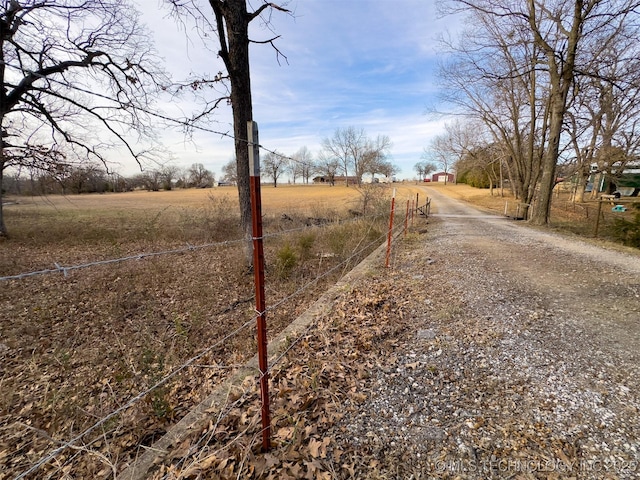 view of street featuring a rural view and gravel driveway