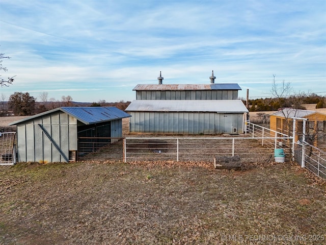 view of pole building with an exterior structure and fence