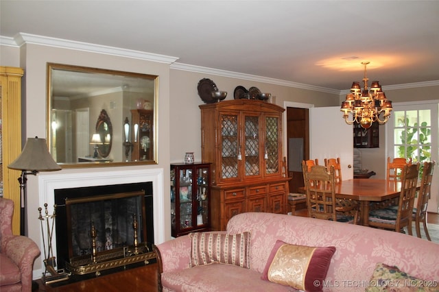 living room with crown molding, a fireplace with raised hearth, a chandelier, and wood finished floors