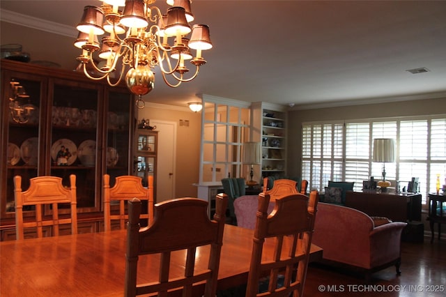 dining area with crown molding, visible vents, wood finished floors, and a notable chandelier