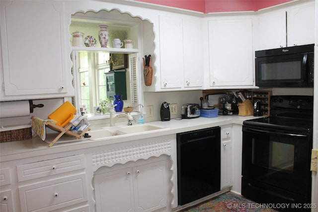 kitchen with light countertops, white cabinets, black appliances, and a sink