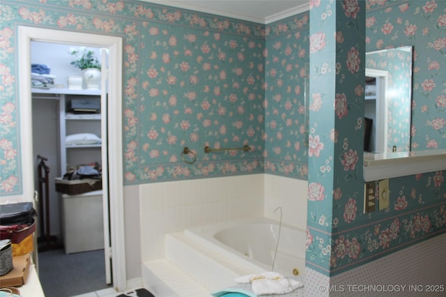bathroom featuring wallpapered walls, ornamental molding, and a bath