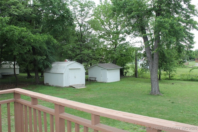 view of yard featuring an outdoor structure, fence, and a shed