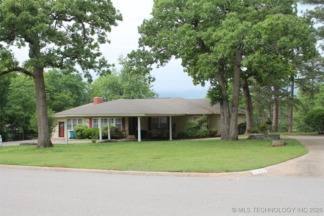 single story home with a chimney and a front yard