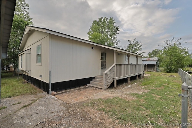 back of property featuring a yard and fence