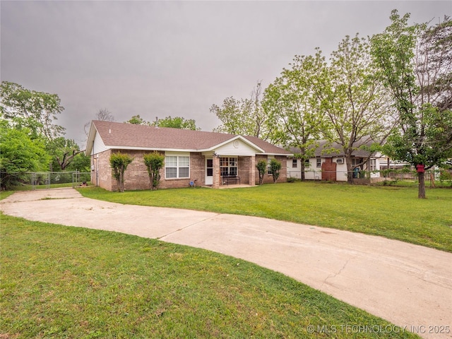 ranch-style home with brick siding, fence, driveway, and a front yard