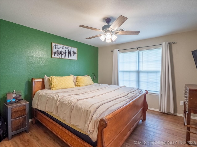 bedroom featuring baseboards, ceiling fan, and wood finished floors