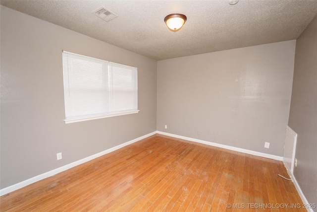 1160 S 124th E Ave, Tulsa, OK 74128 - unfurnished room featuring baseboards, light wood-style flooring, and a textured ceiling