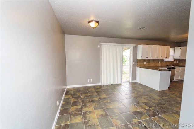 1160 S 124th E Ave, Tulsa, OK 74128 - kitchen featuring dark countertops, white cabinets, backsplash, baseboards, and a peninsula