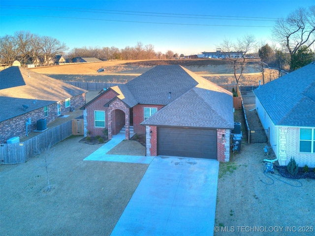 6342 E 148th St S, Bixby, OK 74008 - view of front facade with brick siding, a fenced backyard, roof with shingles, an attached garage, and concrete driveway