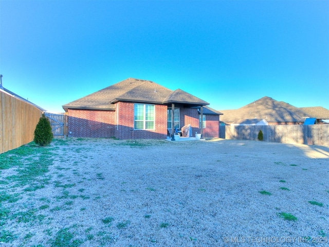 6342 E 148th St S, Bixby, OK 74008 - rear view of house featuring a fenced backyard, a gate, and brick siding